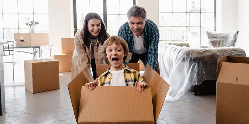 A family playing while packing after learning about how to become a Florida relocation real estate agent