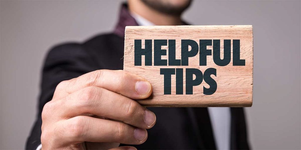 A professional holding a small wooden sign that says ''helpful tips' for CE tests