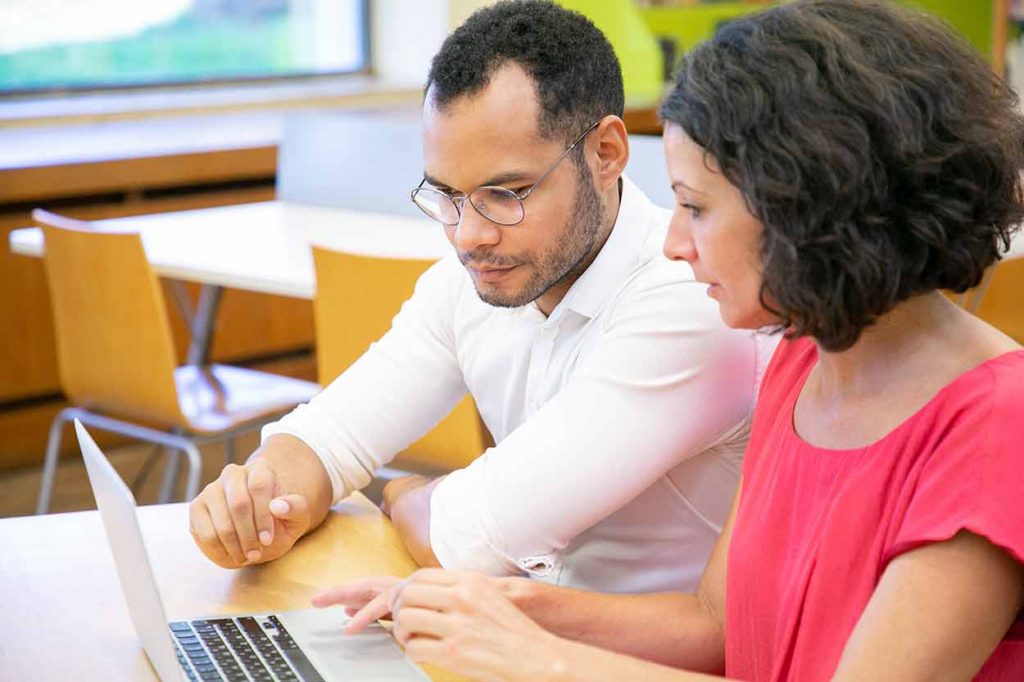 Two Colleagues Studying Using The Latest Technology in Mortgage Loan Licensing